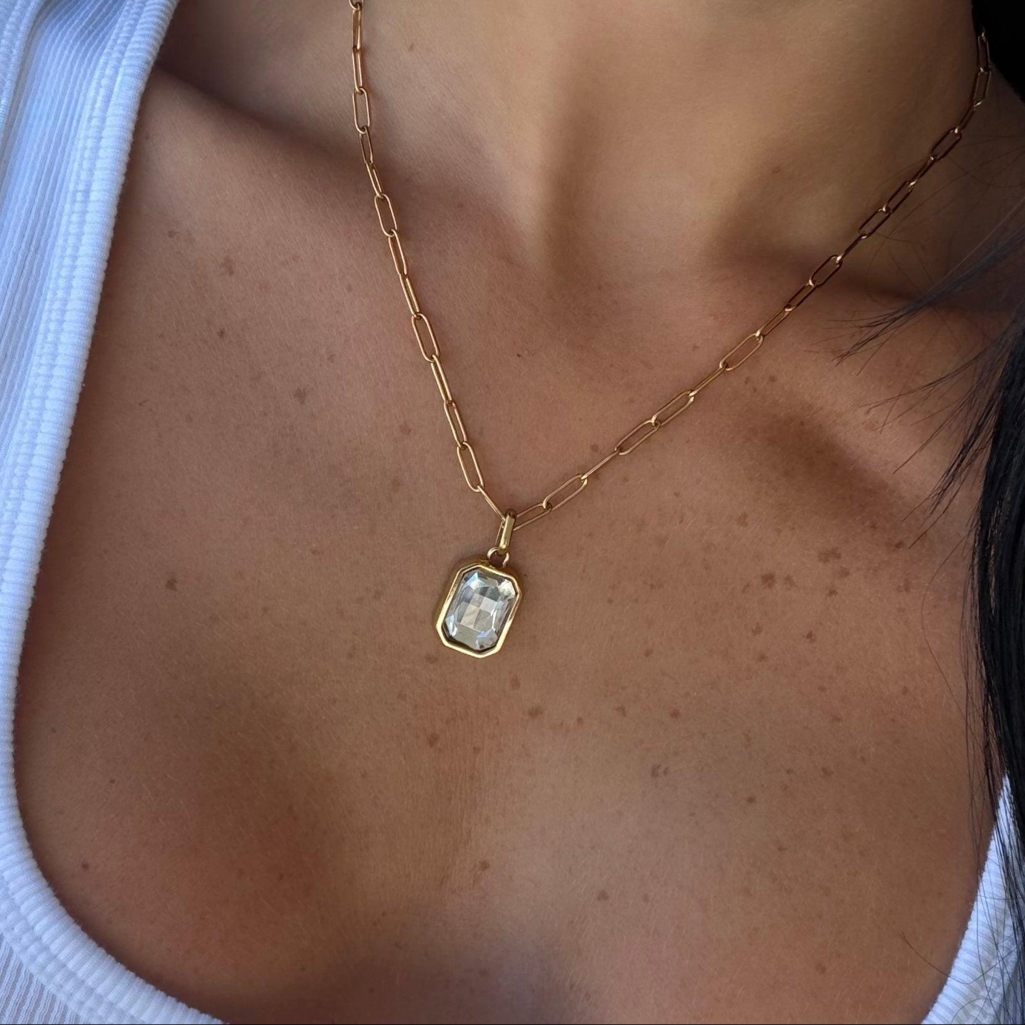 Gold paperclip chain necklace with a rectangular birthstone pendant