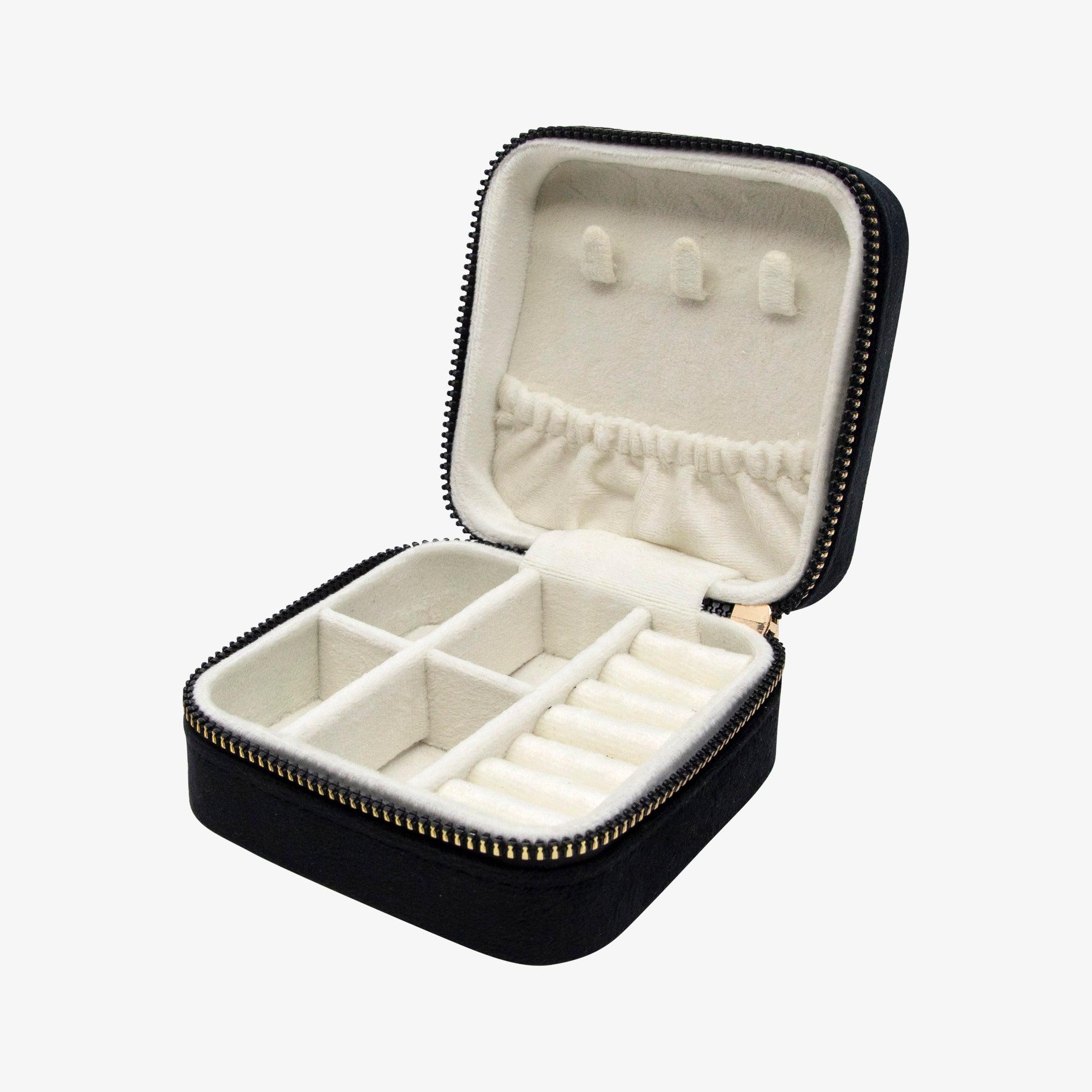 Open black zip jewelry case with cream lined ring rolls and compartments